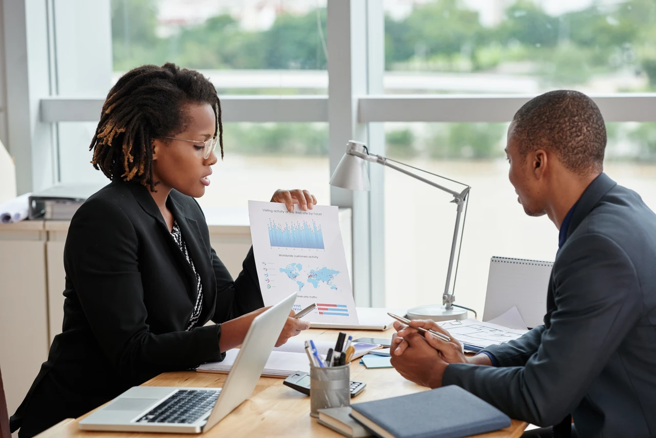 Businesswoman showing analytical charts to her coworker.